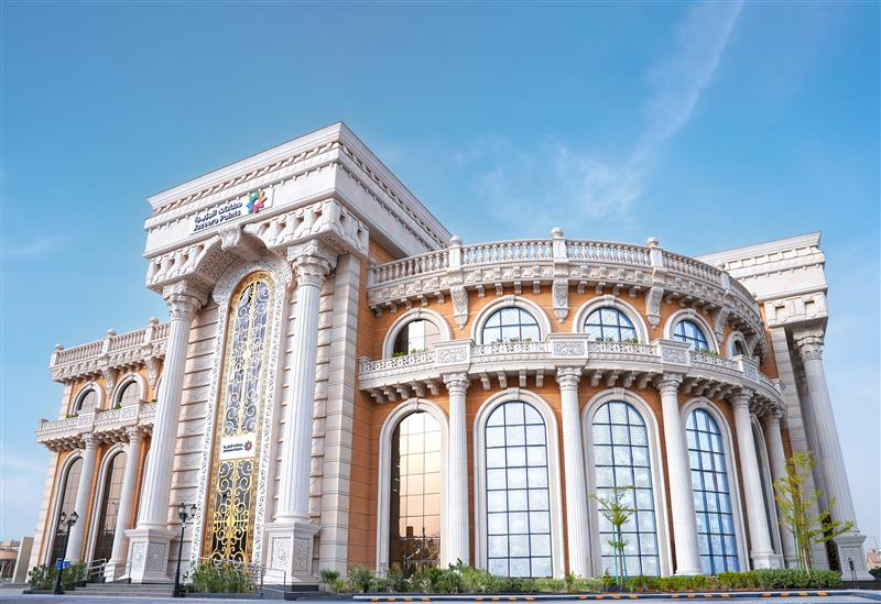 واجهة معرض رئيسي لدهانات الجزيرة بطابع كلاسيكي — أعمدة بيضاء ونوافذ قوسية وسماء صافية